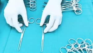 hands reach for surgical tools