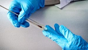 gloved hands holding forensic evidence