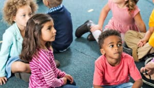 preschoolers sit on rug