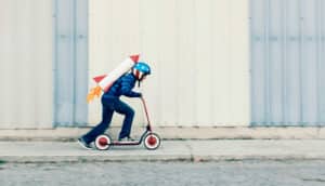 rocket kid with helmet on scooter