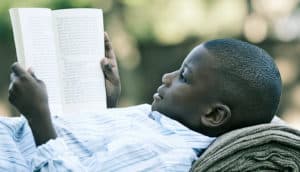 boy reading on his back