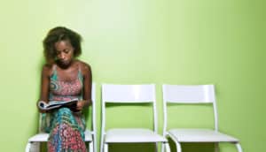 woman reads magazine in green waiting room