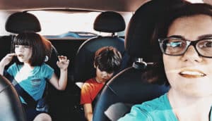 mom with two kids in backseat of car