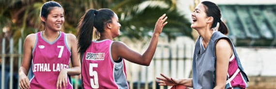 three young women playing basketball