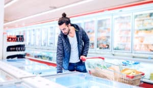 man in frozen food section (refrigeration concept)