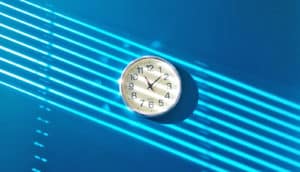 lines of light fall on wall clock on blue wall