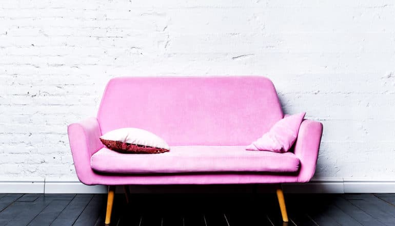 pink couch against white wall