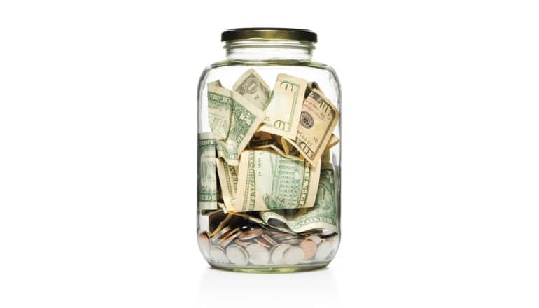 charity - glass jar of paper money and coins