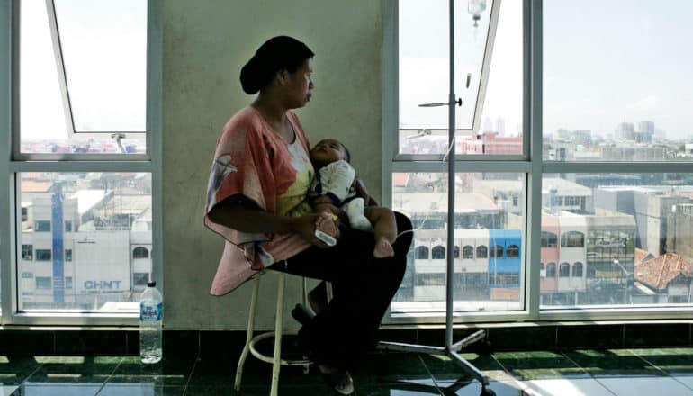 mom holds baby who has dengue fever - flavivirus