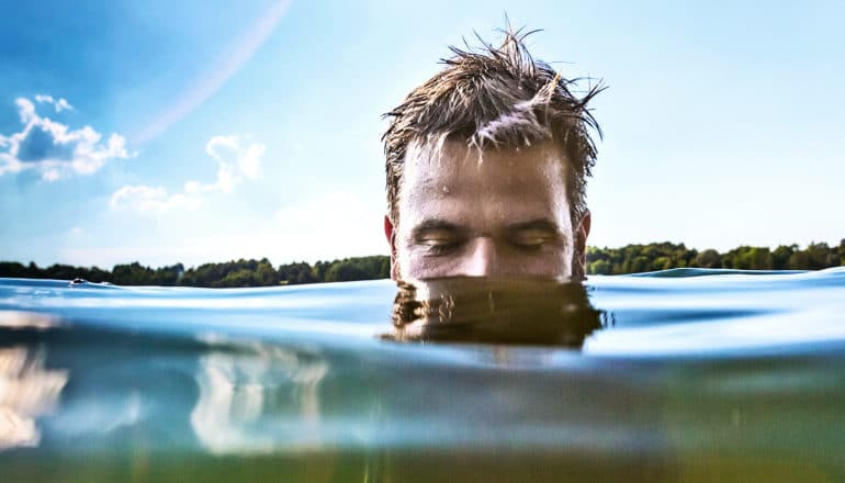 man in water up to nose (flesh-eating bacteria concept)