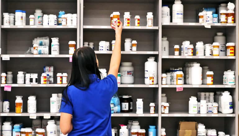 pharmacist reaching for pills (buprenorphine credit)