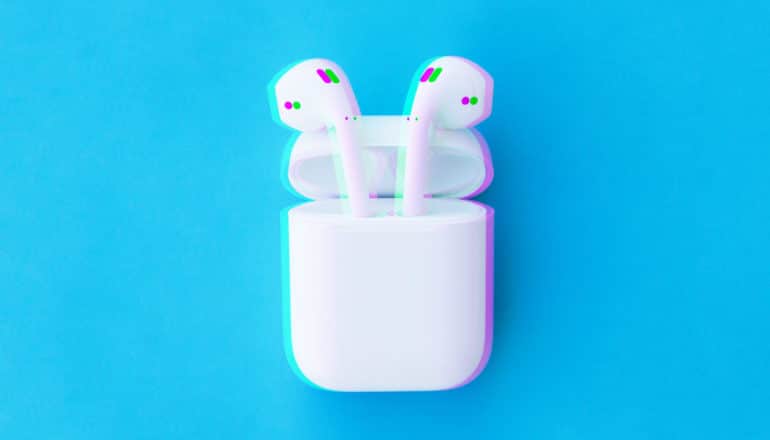 intentionally out of focus airpods in case on blue background