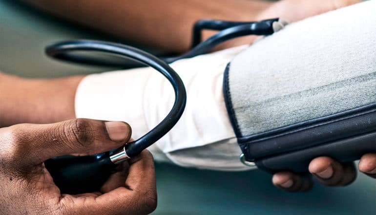 The image shows someone getting a blood pressure test. (dementia concept)