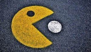 A Pac-Man painted on asphalt eats a white pellet