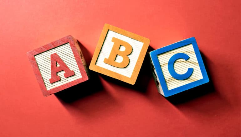 Toy ABC blocks sit on a red background