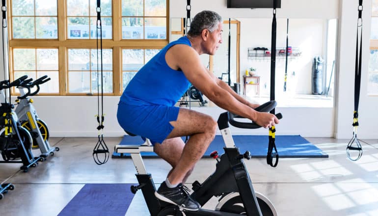 A man rides a stationary bike in a gym