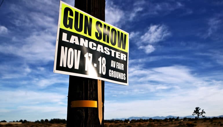 A sign on a telephone pole advertises for a gun show