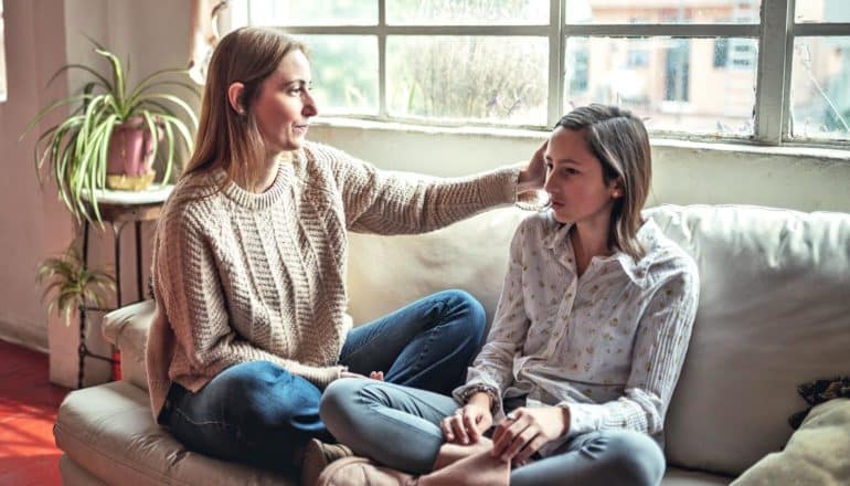 mother and teen on couch mid-conversation