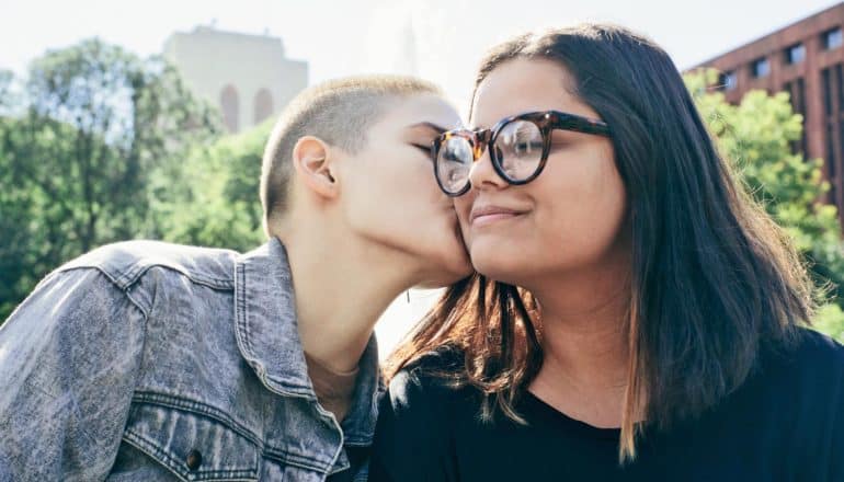 one person kisses another on the cheek