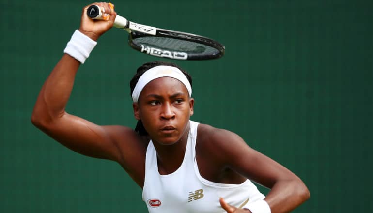 coco gauff holds tennis racket over her head