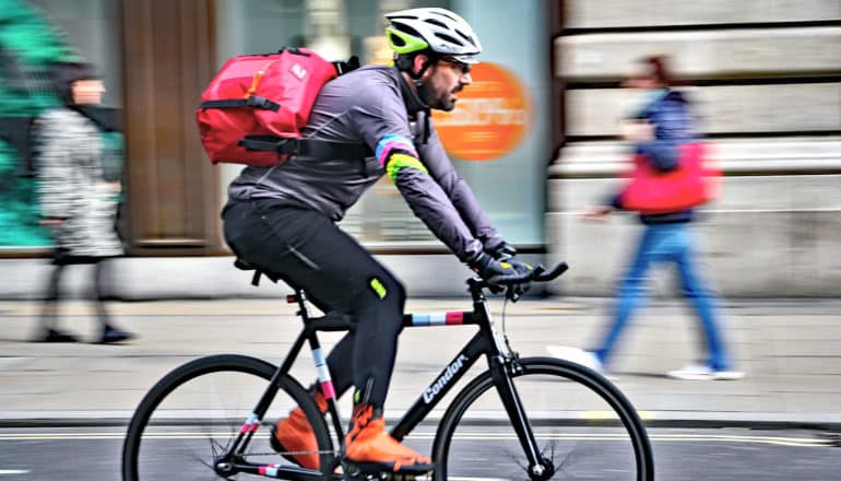 person with messenger bikes on city street