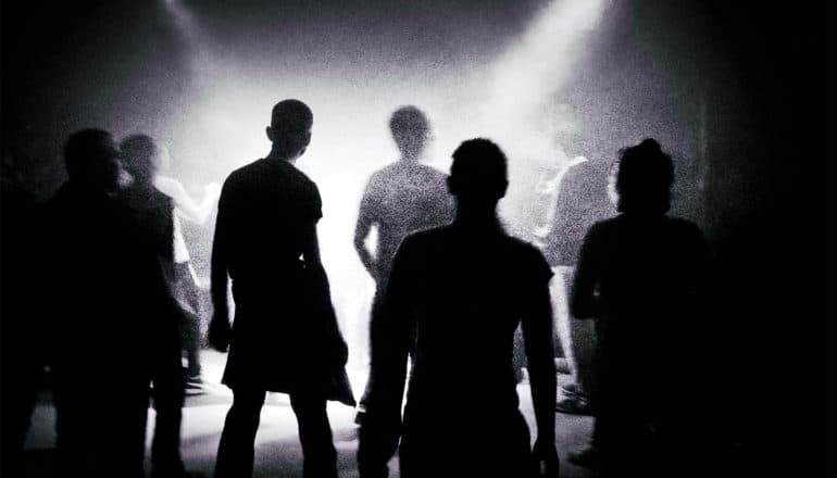 A group of people in silhouette look like a shambling group of zombie