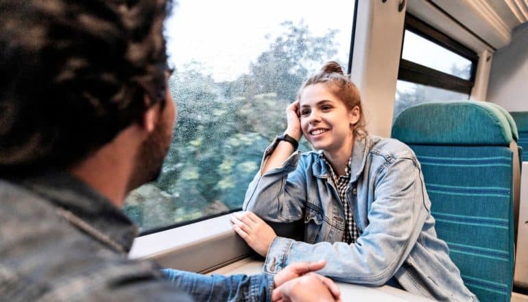 two people chat on a train