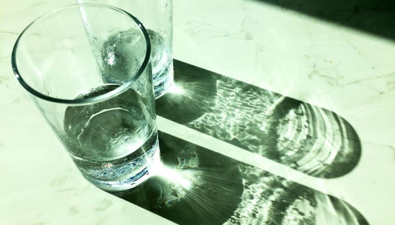 two glasses of water cast shadows on table