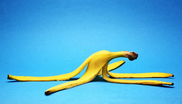 A yellow banana peels sits on a blue background