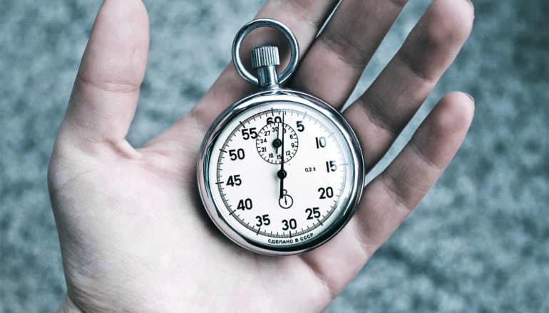 A hand holds a stop watch