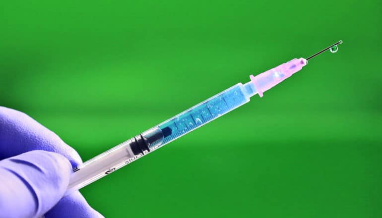 syringe/needle in gloved hand