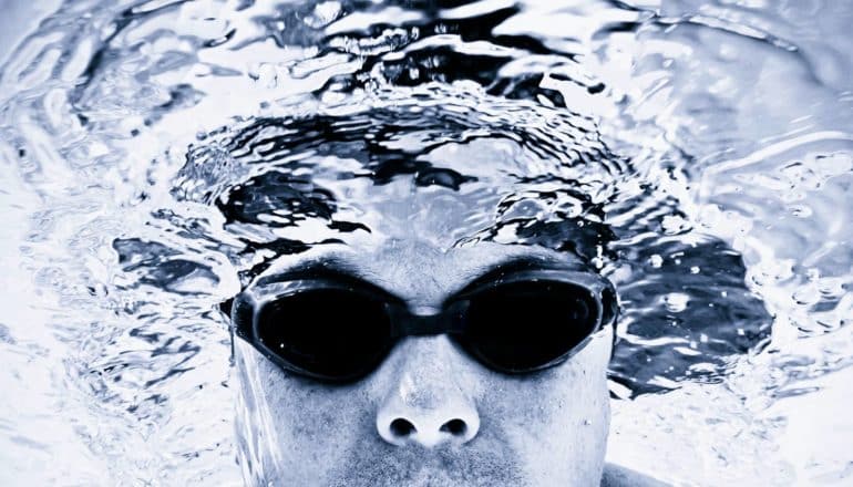 person wearing goggles with head mostly underwater