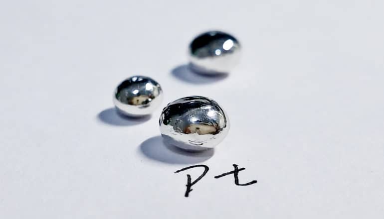 three platinum beads on paper with "Pt" written beneath