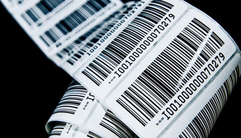 A roll of barcode labels unfurls against a black background