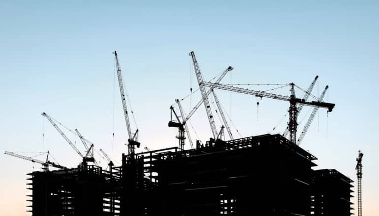 cranes on rooftops in silhouette