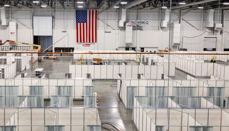 US flag on wall in huge room of medical tents