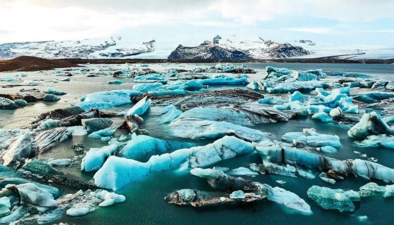 Arctic sea ice looks bright blue in the water