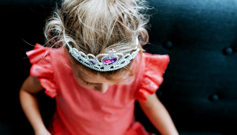 child in frilly top and princess crown