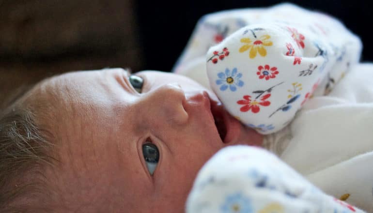 newborn baby in mitten sleeves