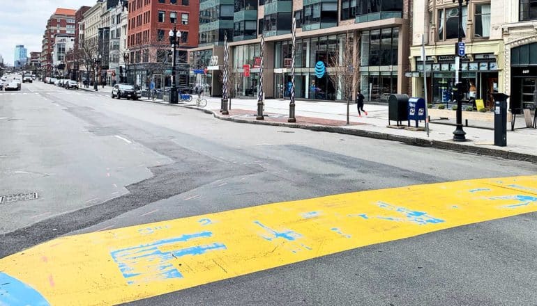 The finish line for the Boston Marathon is yellow on an empty Boston street