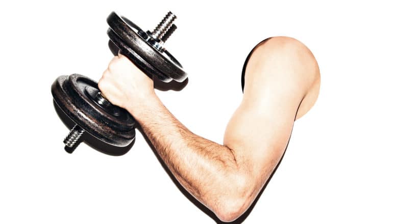 A man's arm sticks through a hole in a white background, while he's holding a dumbbell