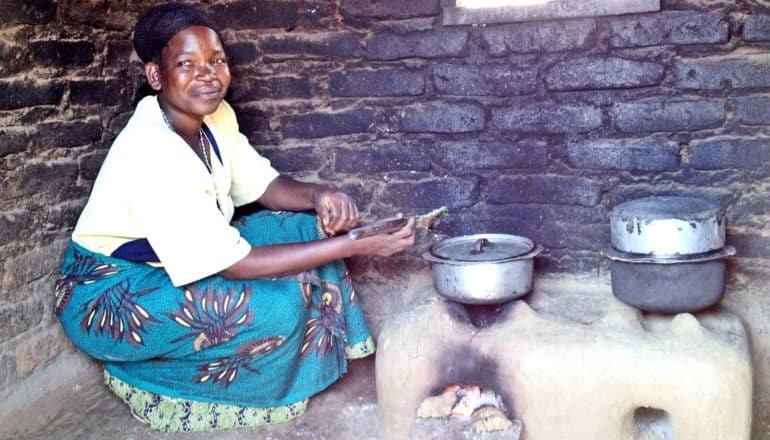 A woman uses a cookstove inside a home