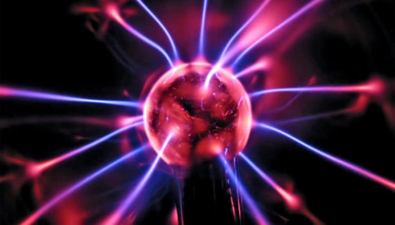 A plasma lamp has a large purple ball at the center with purple strands of energy coming out of it