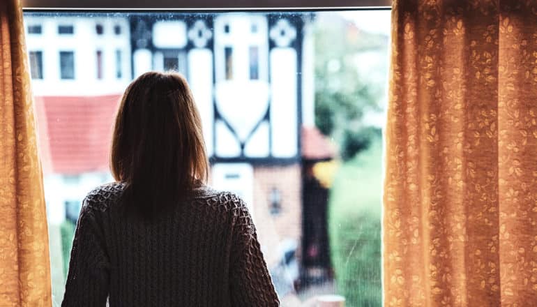 A woman looks out the window