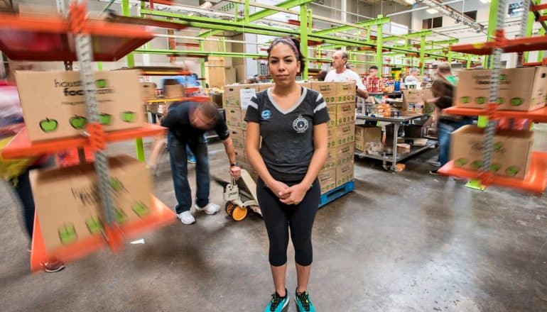 person stands amid busy warehouse