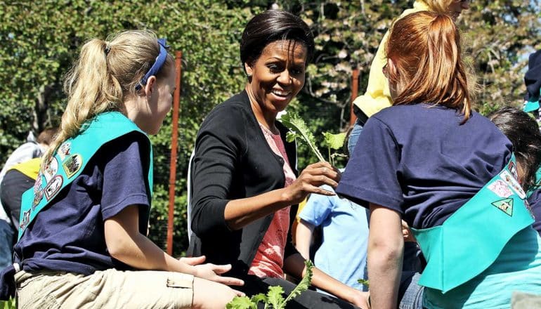 Michelle Obama plants vegetables in the White House garden with two girl scouts