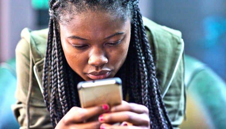 A young woman looks at her phone