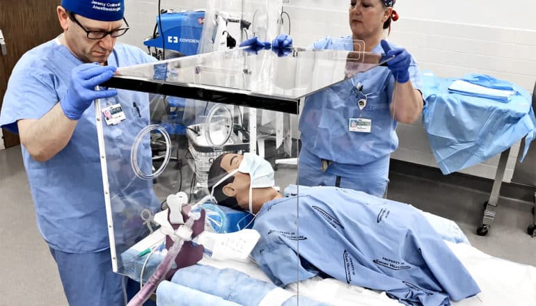 Researchers put together the clear box around a medical dummy on a table