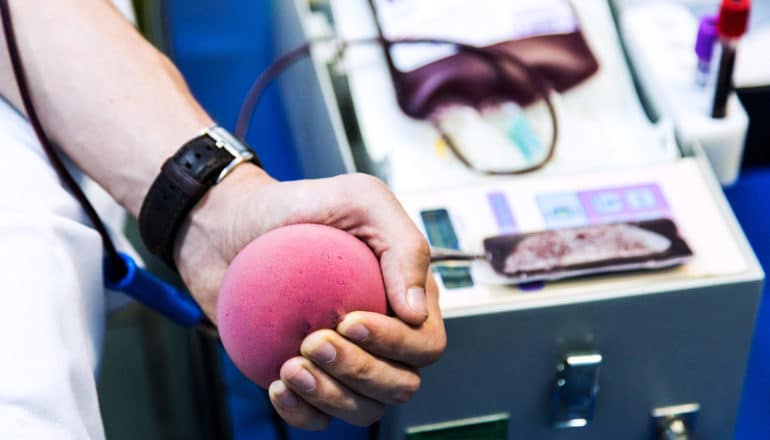 hand squeezes ball during blood donation