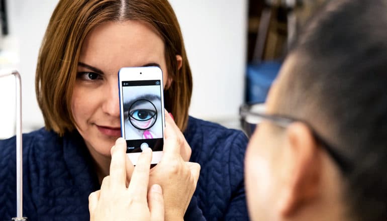 A researcher uses the anemia app to take a picture of another's inner eyelid